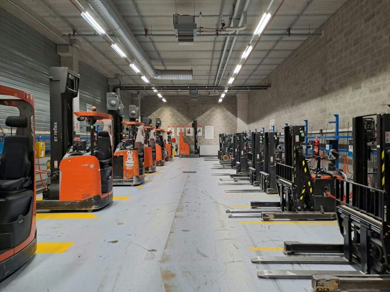 Forklifts moving palletized supplies in a warehouse